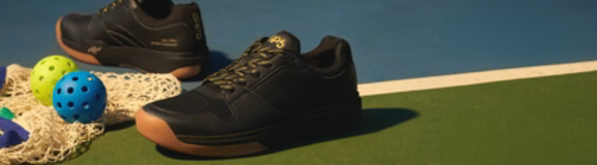 Black pickleball shoes beside net and balls