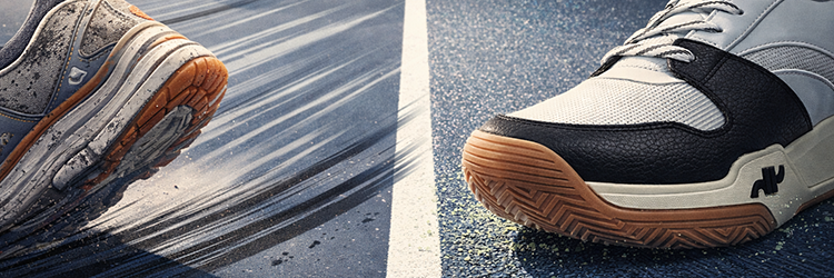 Two pickleball court shoes facing off on a court surface