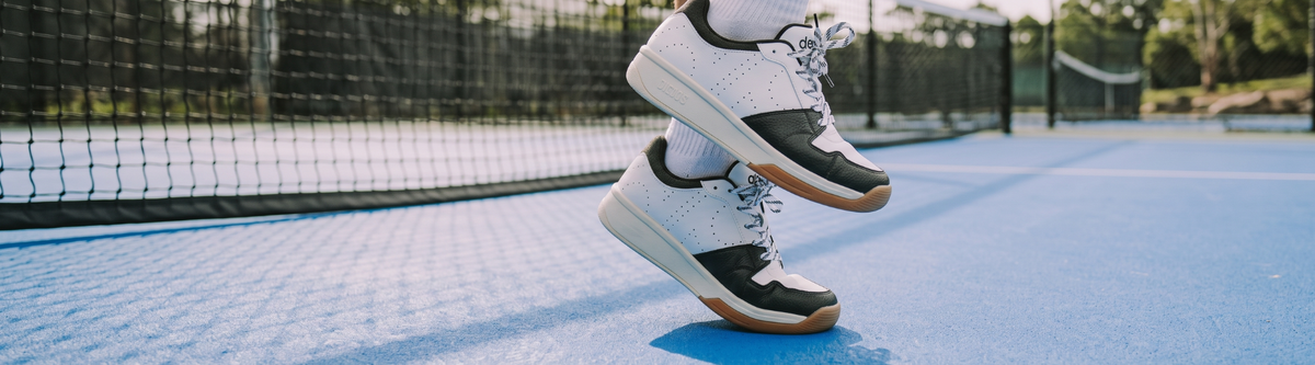 Cushioned pickleball shoes jumping on blue court
