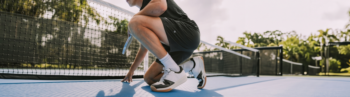 Player crouching in stable pickleball court shoes